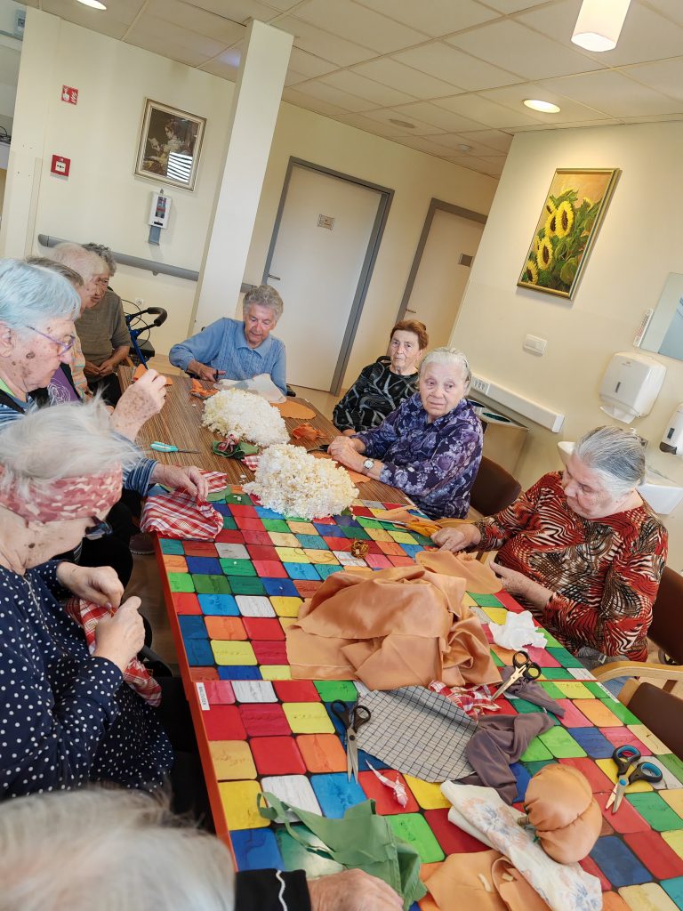 Stanovalci na kreativni delavnici v domu.