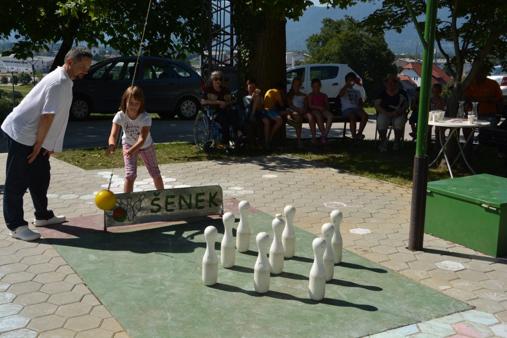 Medgeneracijsko druženje - deklica in stanovalec doma kegljata.